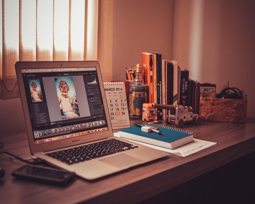 A person working at a bright office desk looking away from the screen