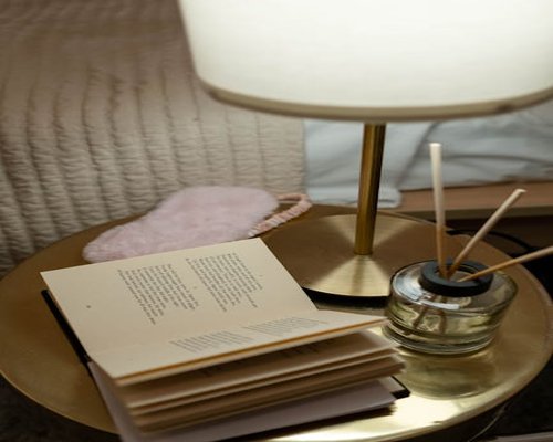 A nightstand with a book and a small lamp ready for sleep